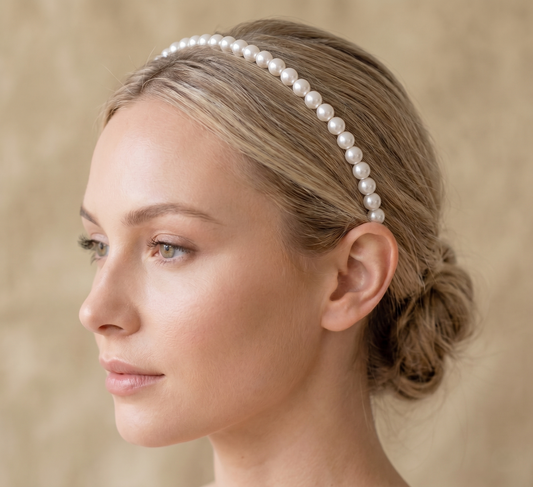 Woman wearing a pearl headband against a beige background