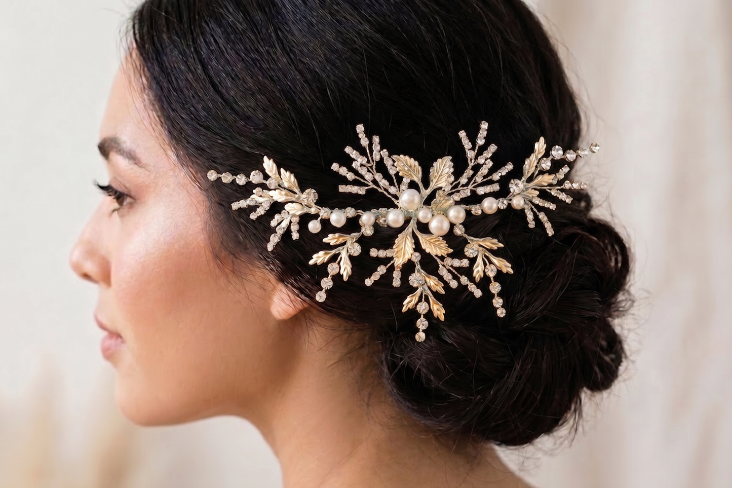 Woman wearing a decorative hairpiece with pearls and gold elements.