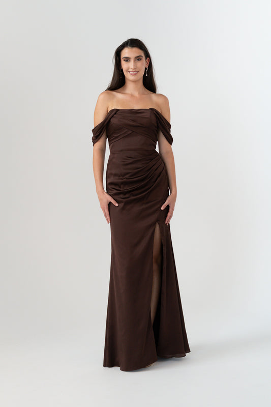 Woman wearing a brown off-shoulder gown on a white background
