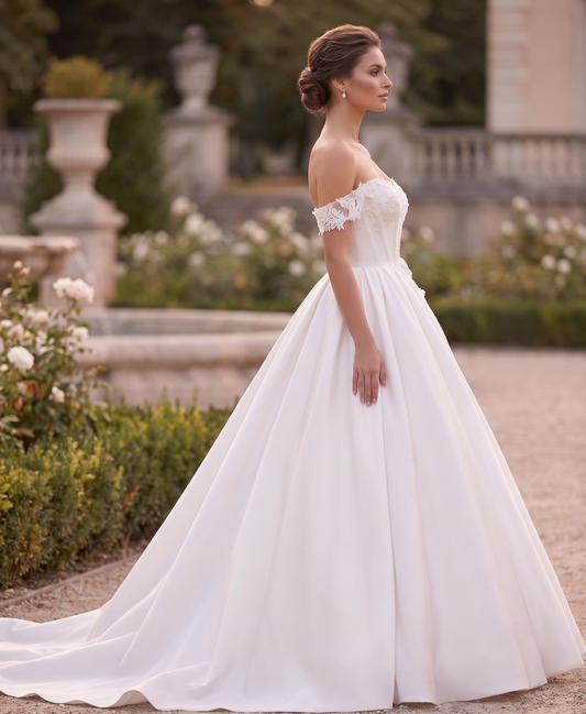 Woman in a white wedding dress standing in a garden setting