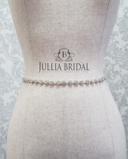 Silver bridal belt on a mannequin with Jullia Bridal logo