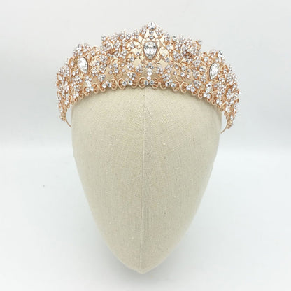 Rose gold tiara with crystals on a mannequin head against a white background
