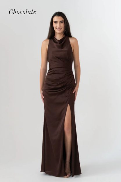 A woman modeling a sleeveless, high-neck, floor-length chocolate brown gown with a ruched bodice and a thigh-high slit, shown against a light gray studio background with the word 'Chocolate' in the top left.