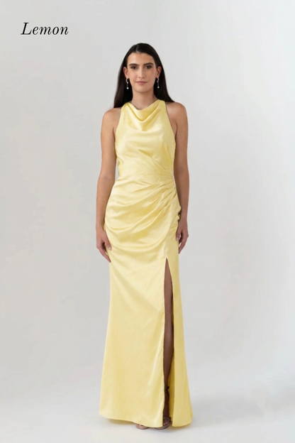 A woman modeling a sleeveless, high-neck, floor-length yellow gown with a gathered ruched bodice and a front slit, shown against a light gray studio background with the word 'Lemon' in the upper left.