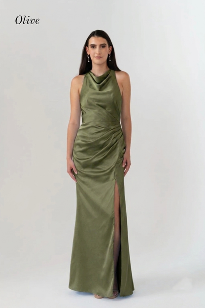 A woman modeling an olive green satin halter-neck maxi dress with a draped bodice and thigh-high slit, shown against a plain light gray studio background. The word 'Olive' appears in the upper left corner.
