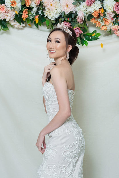 Woman in a white wedding dress with floral decorations in the background