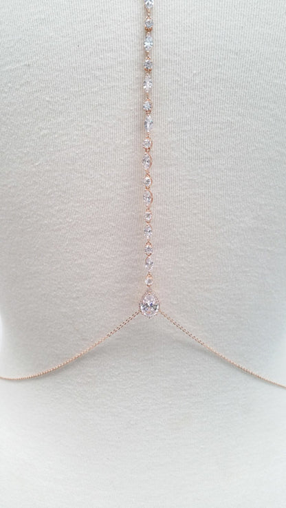 Delicate gold necklace with small diamonds on a light gray background
