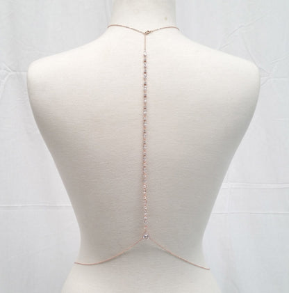 Mannequin wearing a delicate rose gold body chain on a white background