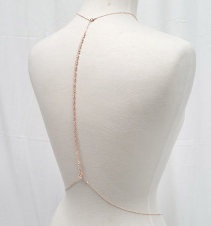 Rose gold body chain on a mannequin against a white background