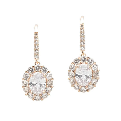 Rose gold earrings with large clear gemstones on a white background