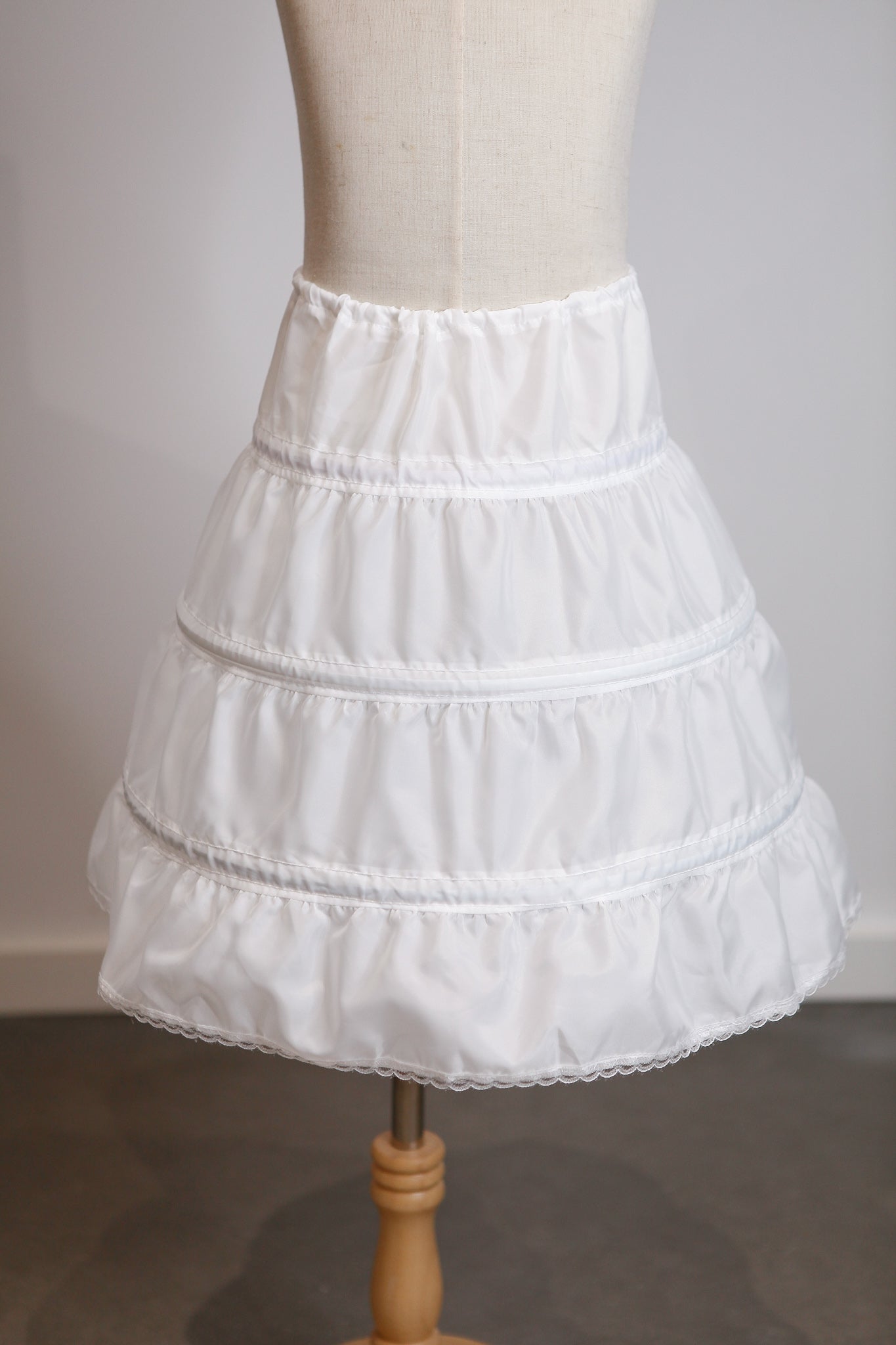 White petticoat on a mannequin against a plain background