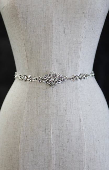 Silver bridal belt on a mannequin with a plain background