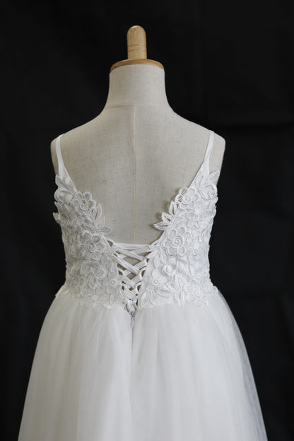 White lace wedding dress on a mannequin against a black background