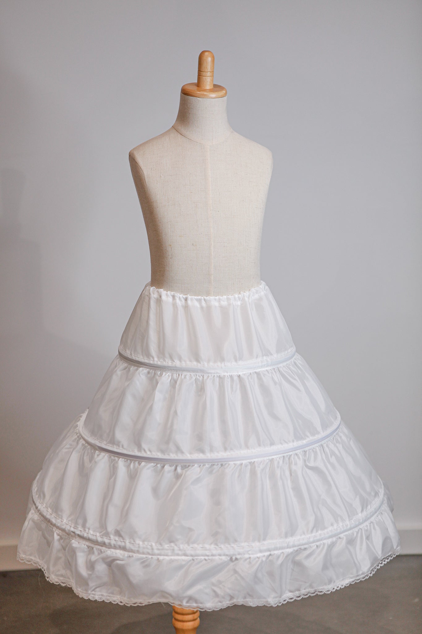 White petticoat on a mannequin against a plain background