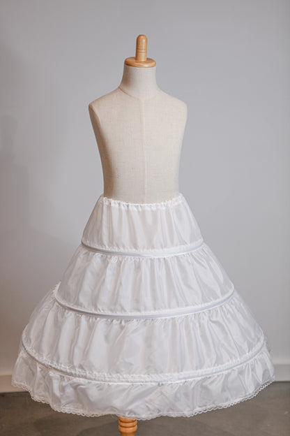 White petticoat on a mannequin against a plain background