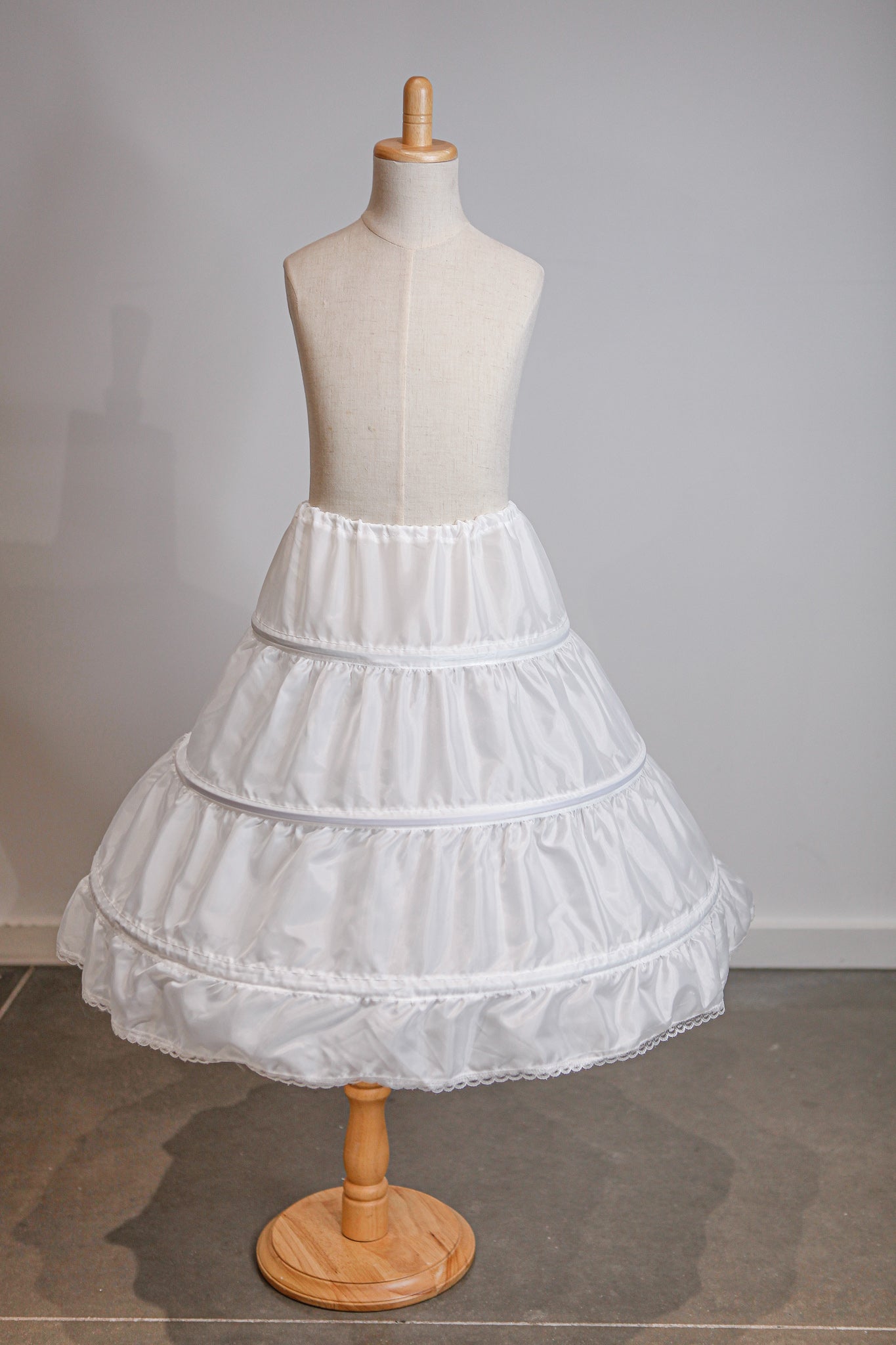 White petticoat on a mannequin against a plain background