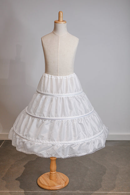 White petticoat on a mannequin against a plain background