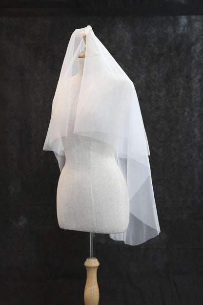 White bridal veil on a mannequin against a dark background
