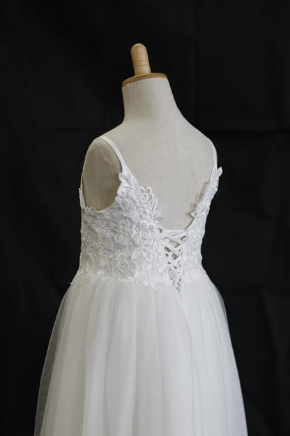 White lace wedding dress on a mannequin against a black background