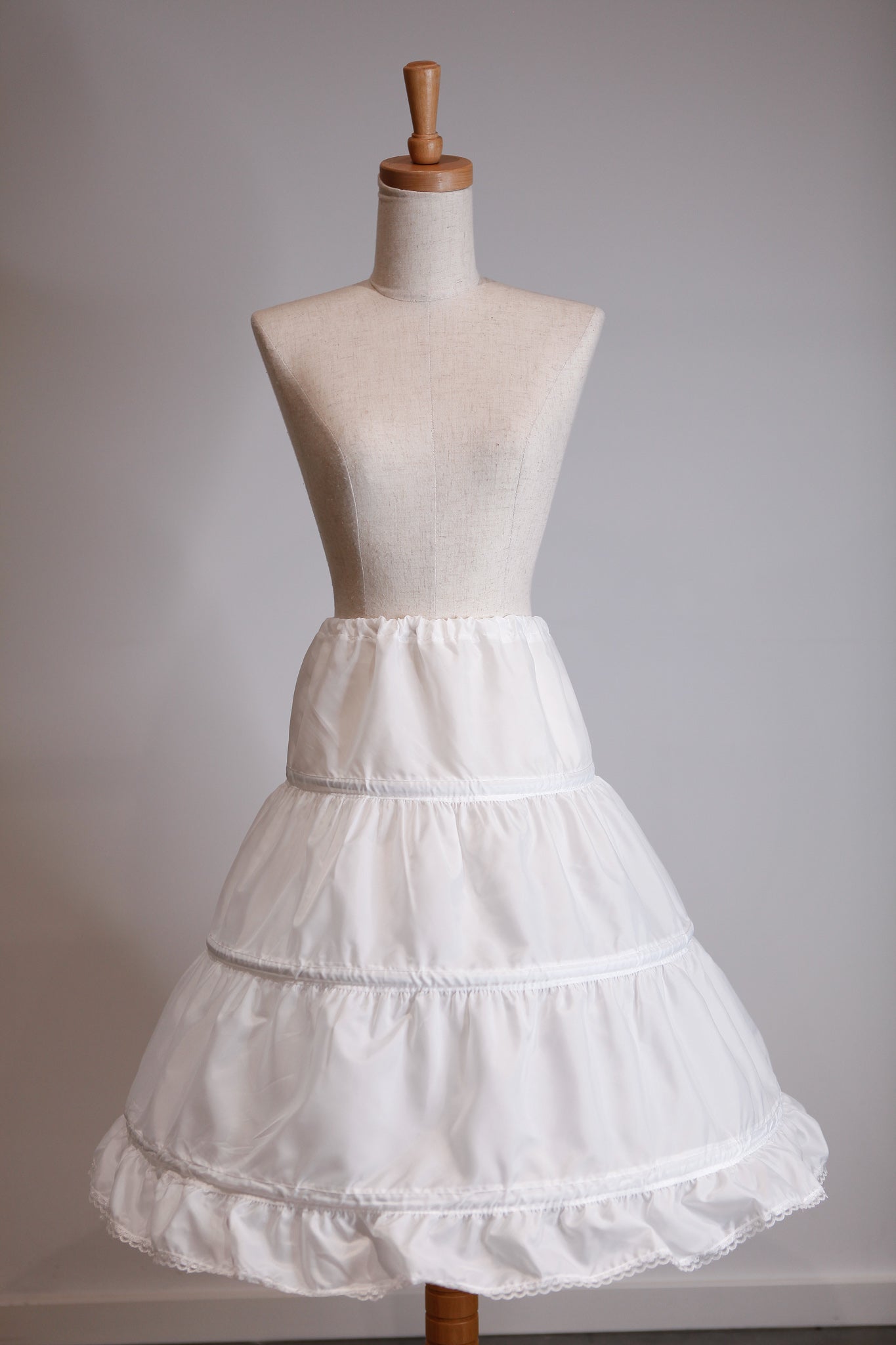 White petticoat on a mannequin against a plain background