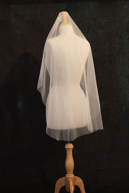 White wedding veil on a mannequin against a black background