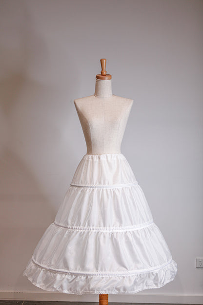 White petticoat on a mannequin against a plain background