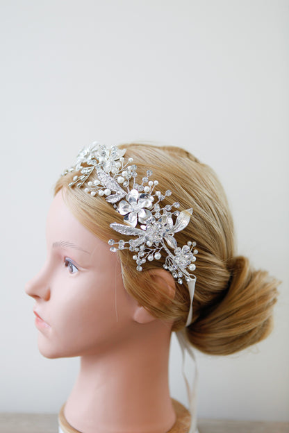 Silver floral hair accessory on a mannequin head with a plain background