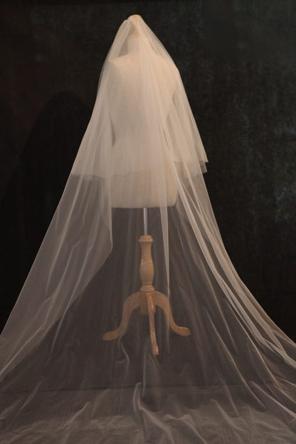White wedding veil on a wooden mannequin against a dark background