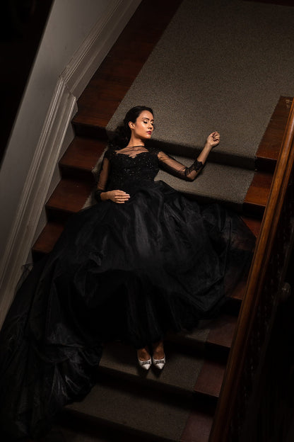 Woman in a black dress sitting on a staircase