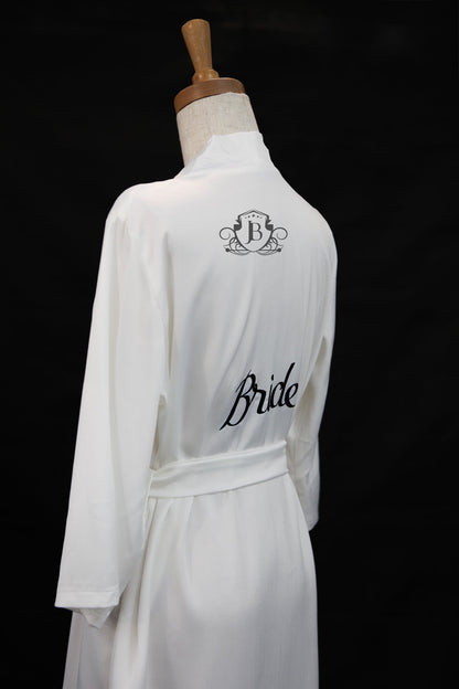 White bridal robe with 'Bride' text on a mannequin against a black background