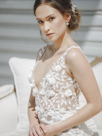 Woman wearing a white floral dress sitting on a couch.
