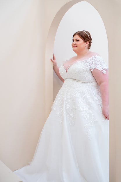 Woman in a white wedding dress standing in an archway