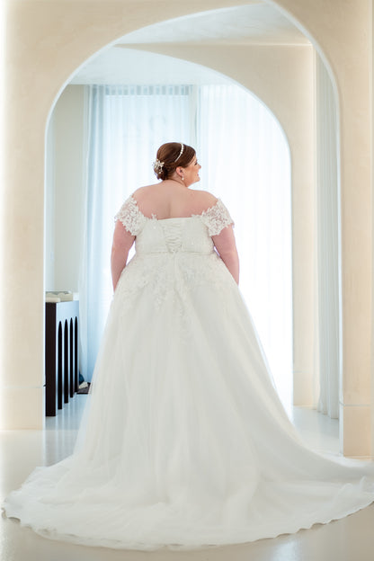 Woman in a white wedding dress standing in an archway