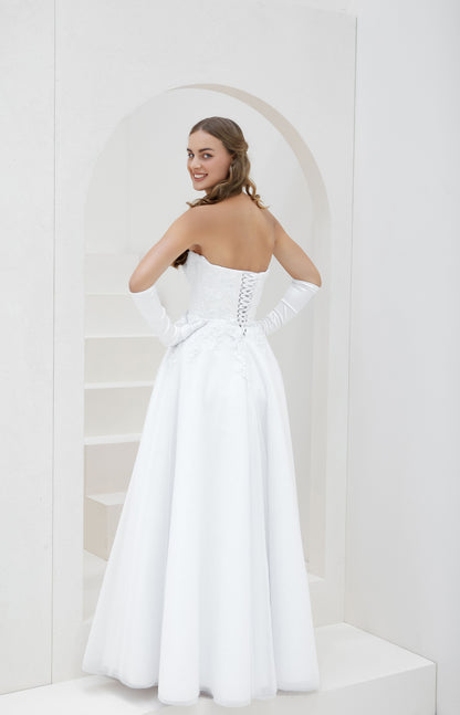 Woman in a white strapless gown standing in a minimalistic setting