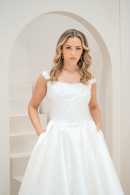 Woman in a white strapless dress standing in a softly lit room with an archway