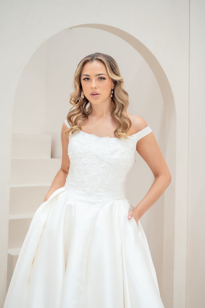 Woman wearing a white wedding dress in a minimalistic setting