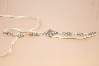 Decorative belt with pearls and crystals on a beige background