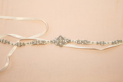 Decorative belt with pearls and crystals on a beige background