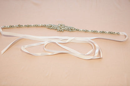 Decorative belt with pearls and a satin ribbon on a beige background