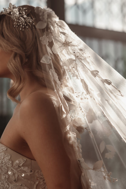 Close-up of a person wearing an ornate wedding veil with floral details