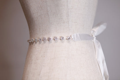 Silver belt with crystals on a mannequin wearing a white dress