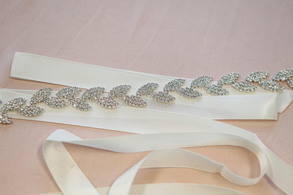 Decorative belt with rhinestone embellishments on a pink background