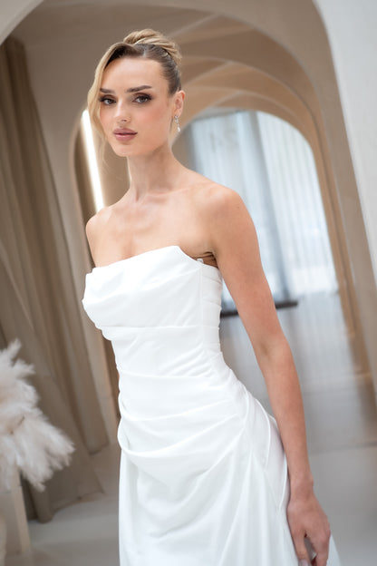 Woman wearing a white strapless dress in an elegant indoor setting