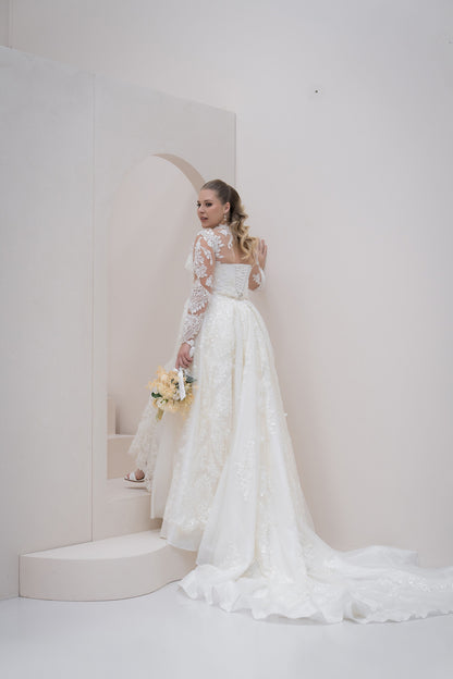 Woman in a white lace wedding dress standing in a minimalistic setting