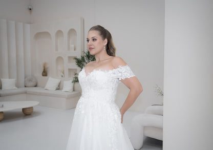 Woman in a white wedding dress standing in a modern living room