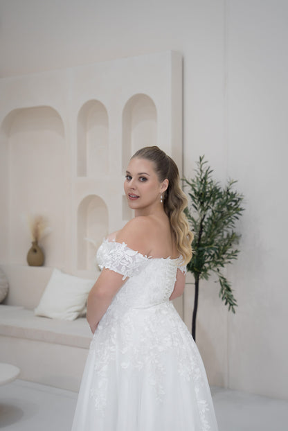 Woman in a white wedding dress standing in a stylish room with arches and decor.