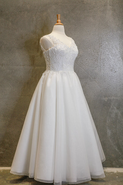 White lace dress on a mannequin against a textured gray background