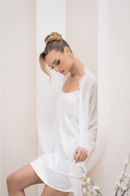 Woman wearing a white lace nightgown against a plain background