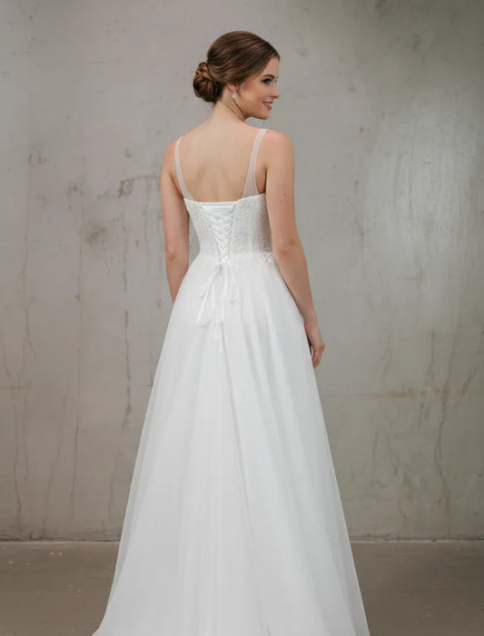 Woman wearing a white wedding dress against a plain background
