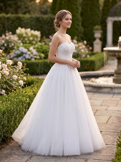 Woman in a white strapless wedding dress standing in a garden.